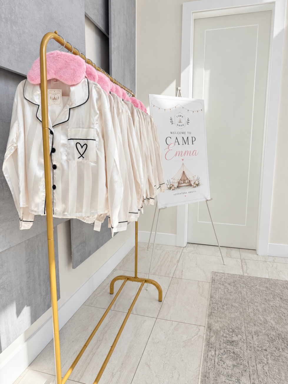 Silk pyjamas with black piping on a gold rack beside the welcome sign