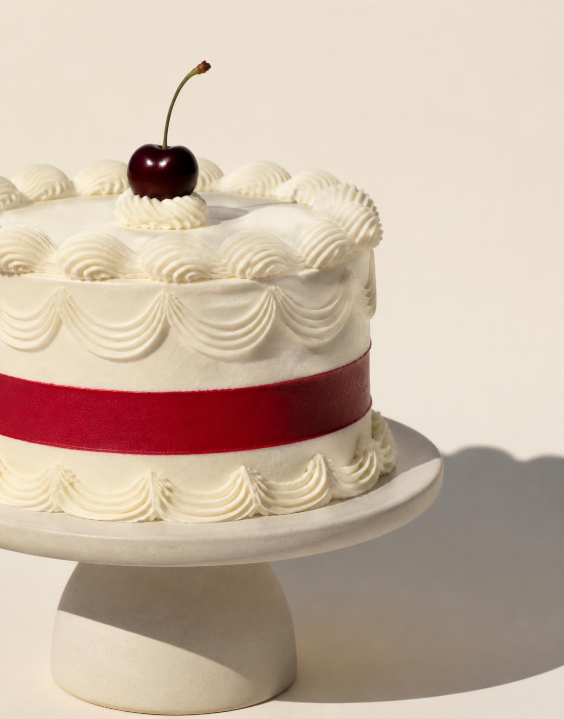 An ivory piped cake with a single cherry-red stripe