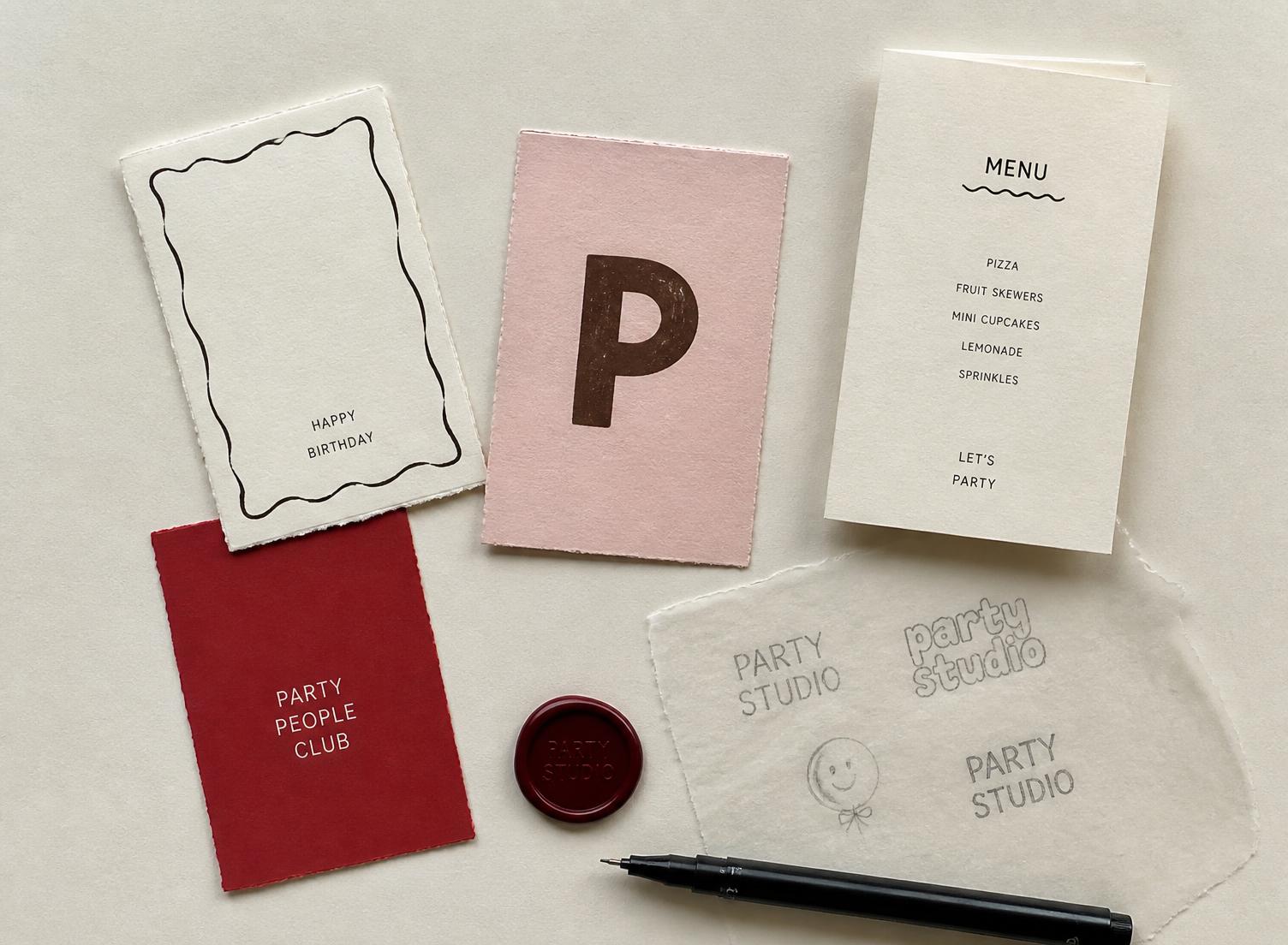 Deckled-edge cards, a folded menu, a wax seal and pencil lettering trials